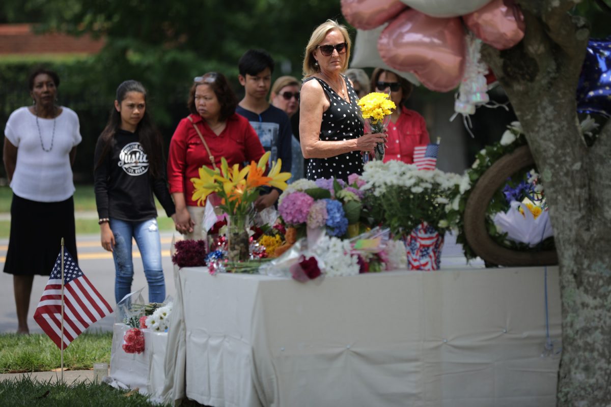 People place flowers at a makeshift memorial