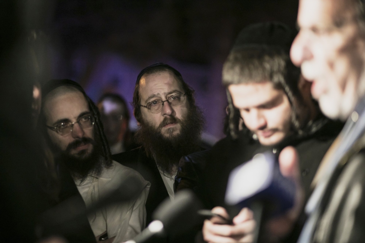 Orthodox Jewish people listen to N.Y. state Assemblyman Dov Hikind